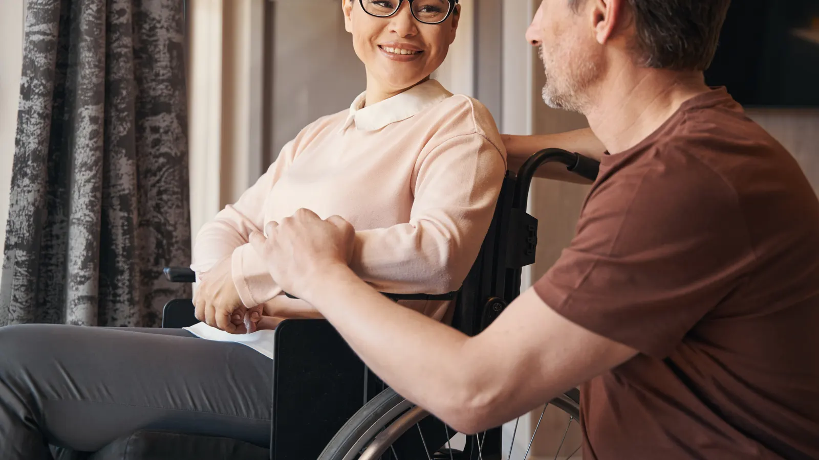 A woman in a wheelchair in conversation with a colleague