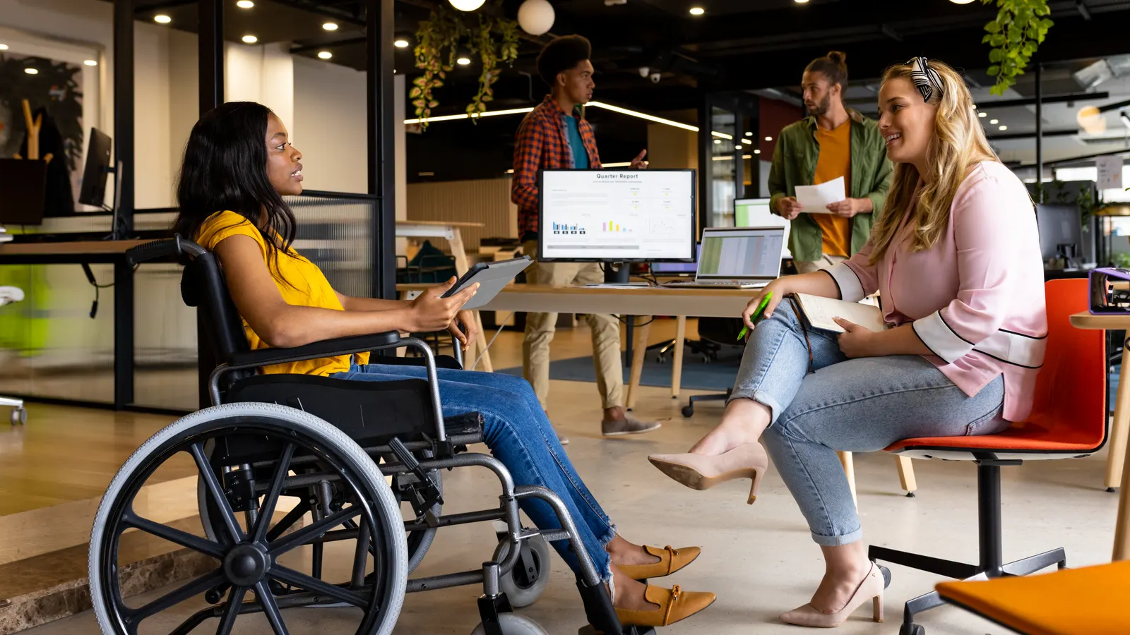 Two colleagues in conversation in a modern open-plan office